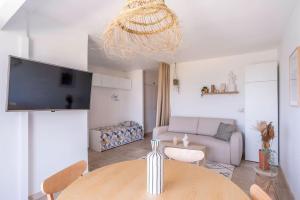 ein Wohnzimmer mit einem Tisch und einem Sofa in der Unterkunft Grand Studio 38m2 vue Mer et Parking ! in Hyères