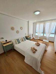 um quarto com uma cama grande com duas toalhas em GATU PREMIUM Villa Turquesa Playa y Parking em Cádiz