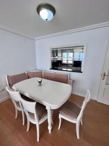 uma mesa branca e cadeiras num quarto em GATU PREMIUM Villa Turquesa Playa y Parking em Cádiz