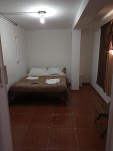 1 dormitorio con 1 cama con 2 toallas en Casa da Dine 02 - Suites sem café, en Campos do Jordão