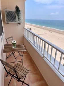 uma varanda com mesa e cadeiras e a praia em GATU PREMIUM Villa Turquesa Playa y Parking em Cádiz