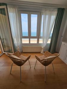 Duas cadeiras num quarto com uma grande janela em GATU PREMIUM Villa Turquesa Playa y Parking em Cádiz