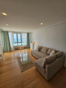 uma sala de estar com um sofá e uma mesa de vidro em GATU PREMIUM Villa Turquesa Playa y Parking em Cádiz