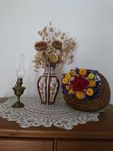 a vase and a basket of flowers on a table at La Croisée Des Chemins in Maisonnais-sur-Tardoire +16 photos