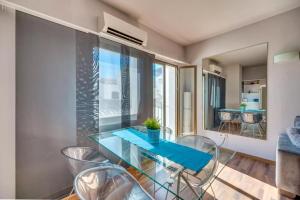 una sala da pranzo con tavolo in vetro e sedie di Chic Designer Apartment a Marbella