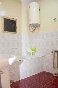 a bathroom with a sink and a chair on a tub at Jolie Maison in Nouakchott