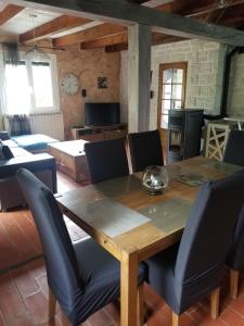 uma sala de jantar com uma mesa de madeira e cadeiras em Maison proche embrun em Baratier