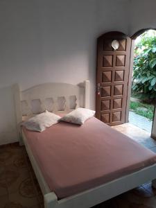 uma cama num quarto com uma porta e uma cama sidx sidx em Hostel Canto de Bertioga em Bertioga