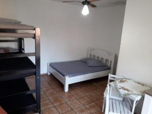 1 dormitorio con 1 cama y ventilador de techo en Hostel Canto de Bertioga en Bertioga