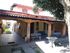 a patio of a house with a bench and a table at Hostel Canto de Bertioga in Bertioga