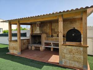 eine Außenküche mit einem Außenbackofen im Hof in der Unterkunft Agradable Villa con Piscina y BBQ. in San Vicente del Raspeig