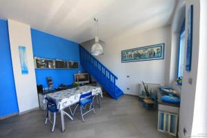 a blue room with a table and a blue staircase at La Casa Sulla Spiaggia in Flumini di Quartu