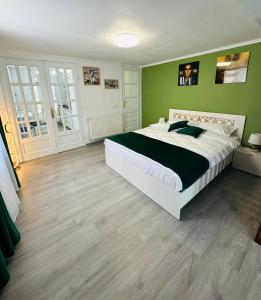 a bedroom with a large bed and green walls at Luxor Apartament Sibiu in Sibiu