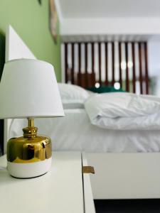 a lamp on a table next to a bed at Luxor Apartament Sibiu in Sibiu