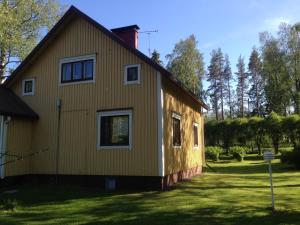 ein gelbes Haus mit einem roten Kamin in der Unterkunft Idylli omakotitalo lähellä pandakarhuja Ähtärissä 