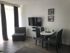 a living room with a table and chairs and a television at City Apartment am Dom in Cologne