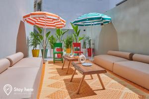 Stayhere Casablanca - CIL - Vibrant Residence في الدار البيضاء: غرفة معيشة بها كنبتين ومظلتين