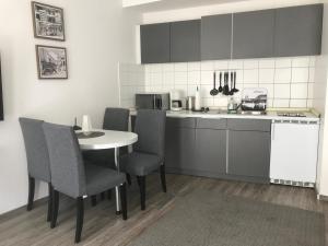 eine Küche mit einem Tisch, Stühlen und einer Theke in der Unterkunft City Apartment am Dom in Köln