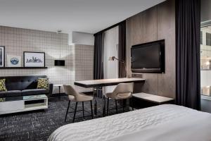 a hotel room with a bed and a tv at Le Meridien Dallas by the Galleria in Dallas