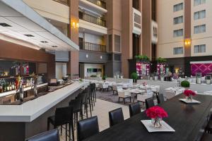 a restaurant with tables and chairs and a bar at Le Meridien Dallas by the Galleria in Dallas