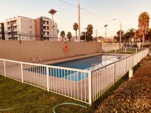 una piscina con una valla blanca alrededor en ARRIENDO EXCLUSIVO DPTO en LA SERENA, en La Serena