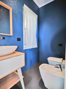 een blauwe badkamer met een wastafel en een toilet bij La Valle Incantata in Lerici