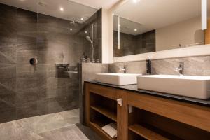 een badkamer met 2 wastafels en een douche bij PUR Suites & Chalets in Lermoos