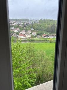 a view of a green field from a window at Bel appartement cosy proche de la frontière Suisse in Villers-le-Lac