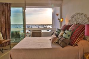 a bedroom with a bed with a view of the ocean at Sabina Suites - Astbury Formentera in La Savina