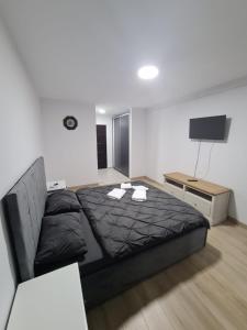 een slaapkamer met een zwart bed en een televisie bij Garsoniera lux Lorena&Kevin in Piteşti