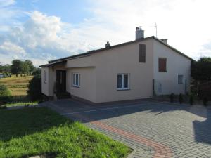 a white house with a driveway in front of it at Dom z winnicą in Morąg