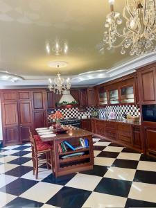 eine große Küche mit einem Tisch und einem Kronleuchter in der Unterkunft Luxurious Oasis: Exquisite Apartment with Garden, Terrace, and Stylish Amenities in Kholodnovidka