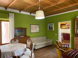 a green living room with a couch and a table at La Stella Danzante B&B in Camerata Vecchia