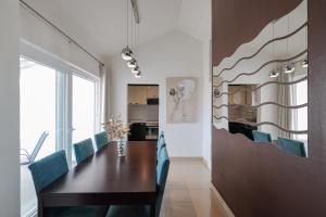 ein Esszimmer mit einem Tisch und blauen Stühlen in der Unterkunft Apartman Andy in Zadar