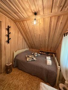 a bedroom with a bed in a wooden ceiling at Quiet Log House, Vaikne palkmaja, Kevadekuulutaja, Harbinger of spring in Rannaküla