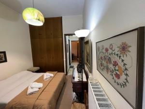 ein Schlafzimmer mit einem Bett und einem Gemälde an der Wand in der Unterkunft Traditional House in Peraia