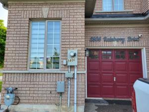 een rood bakstenen gebouw met een rode garage bij 4 bedrooms 4 baths complete Home in Churchill Meadows, Mississauga in Mississauga