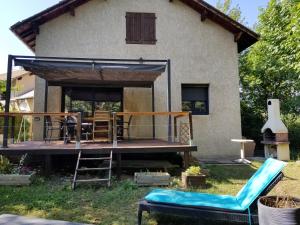 uma casa com um deque e cadeiras no quintal em Maison proche embrun em Baratier