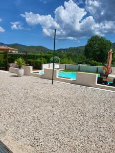 a patio with a swimming pool and a umbrella at Lobeal in Auriol