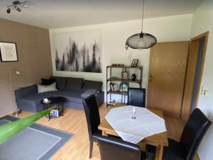 ein Wohnzimmer mit einem blauen Sofa und einem Tisch in der Unterkunft Haus Wiesengrund in Winterberg