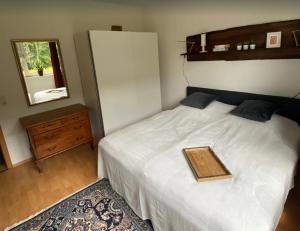 a bedroom with a white bed with a wooden tray on it at Haus Wiesengrund in Winterberg