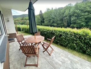 a patio with a table and chairs and an umbrella at Haus Wiesengrund in Winterberg