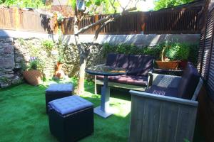 a garden with a table and chairs and a table and a tree at InTown Suite in Lefkada Town