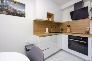 een keuken met witte kasten en een wastafel bij Apartment Ena in Crikvenica