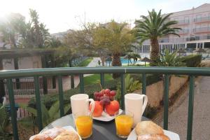 una mesa con una bandeja de fruta y bebidas en el balcón en JM - St James, apart com WIFI, piscina a 50 mt da Praia, en Lagos