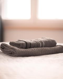 a pile of towels sitting on top of a bed at Modernes City-Apartment mit Blick in den Park und 2 Bäder H9 in Oldenburg