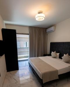 a bedroom with a large bed and a window at Orient Queen Homes Hotel in Beirut