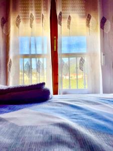 1 dormitorio con cama y ventana con vistas en CASA BRIGIDA, en Jerte