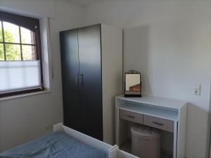 a bedroom with a cabinet and a bed and a desk at Ferienwohnung Am Stadtfeldgraben in Telgte