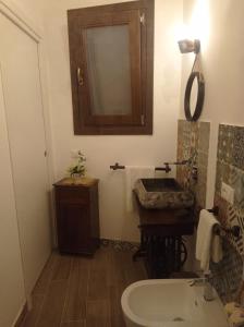 a bathroom with a sink and a toilet and a mirror at casa vacanze pupo 2.0 in Favignana